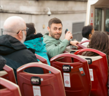 Tourists enjoying a scenic ride through London on an iconic double-decker bus.