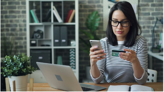 A woman completing her shopping online and entering her card details