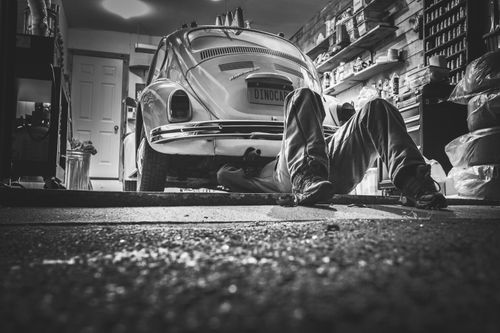 A person repairing a car after saving on a manual with a Haynes coupon code from Love Discount Vouchers