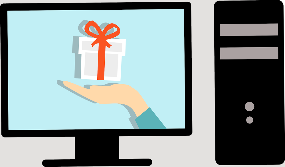 Eine Hand mit Geschenk auf einem Monitor-screen nebene einem Computer