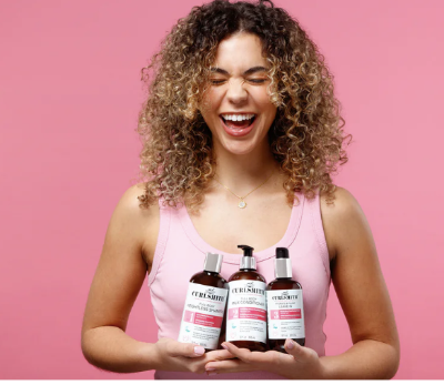 A lady holding Curlsmith products she purchased with a discount code