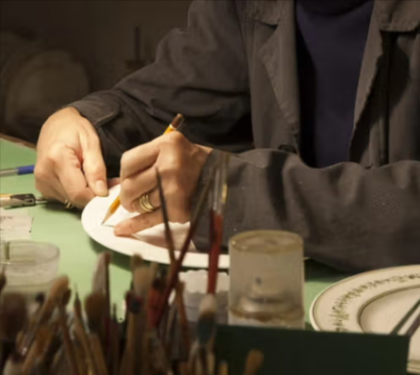 A person hand painting an Artemest plate