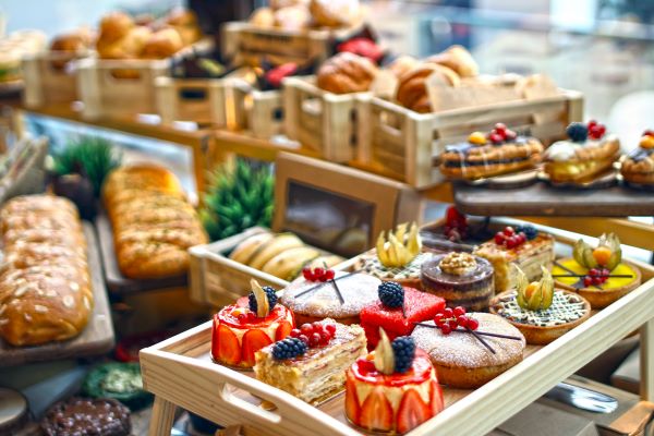Assorted pastries and desserts placed on wooden trays in a bakery
