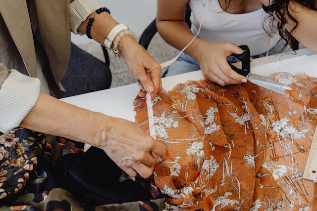 How to measure curtains for Dunelm: Two women measuring and cutting fabric