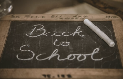 A Back to School signage written on a small board using white chalk