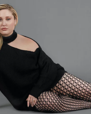 A lady wearing a black off shoulder sweater and black ELLE fishnets