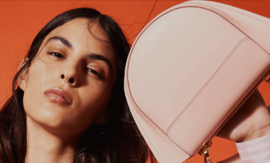 donna che indossa una borsa di colore rosa acquistata con un codice sconto Divo Boutique