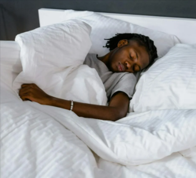 A man sleeping on the DreamCloud bedframe bundle
