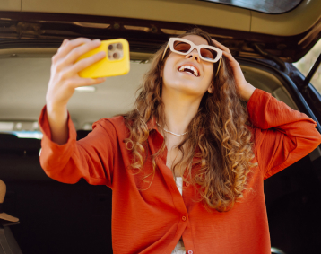 persona detrás de un coche alquilado de budget con un teléfono amarillo