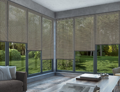 A modern room with large windows, a dark brown couch, and a wooden coffee table and showing a nice outdoor view