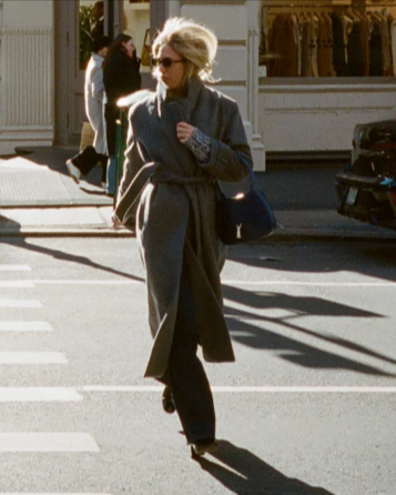 A lady crossing the street wearing a grey ALIGNE George wrap coat