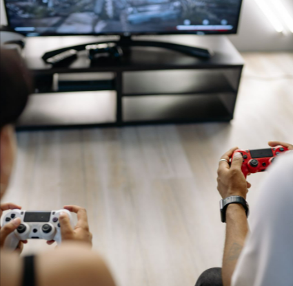 Two friends enjoying video games in a comfortable home environment, focused on intense gameplay bought from the G2A outlet section.