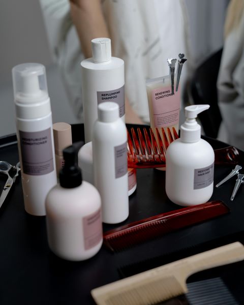 Bottles of hair products and hair accessories on a table