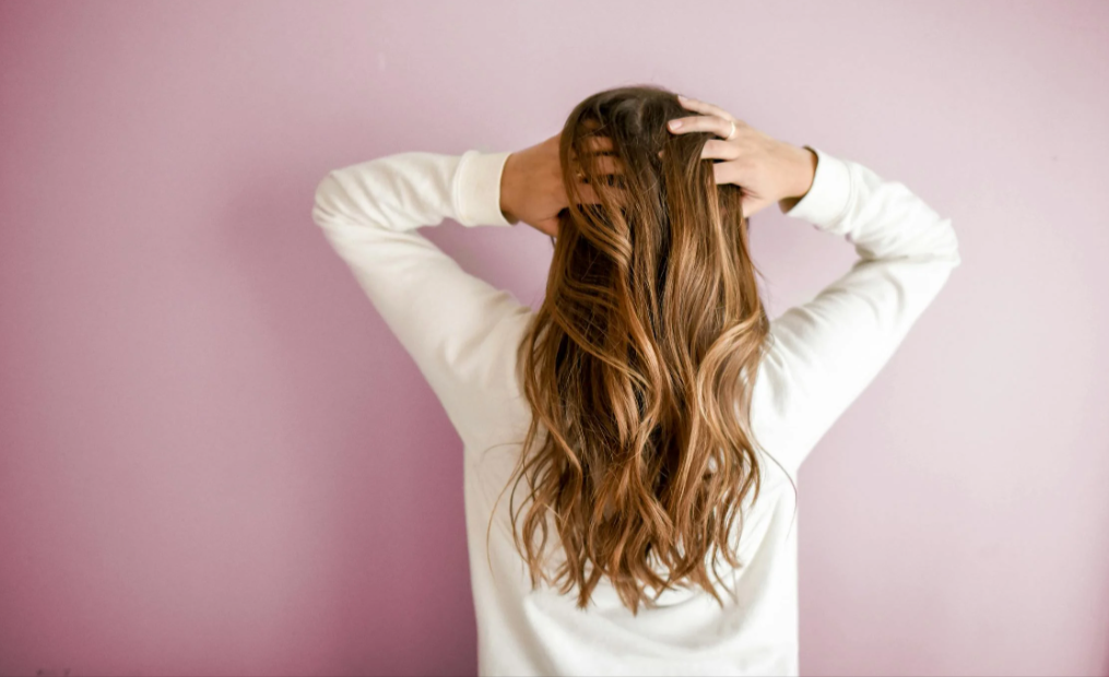 donna che si tiene i capelli lisci grazie all'utilizzo di un prodotto CRLab comprato con un codice sconto CRLab
