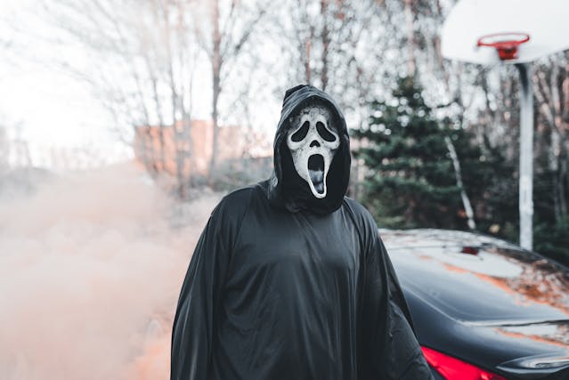 Halloween party theme ideas: A person wearing a Ghostface mask for Halloween