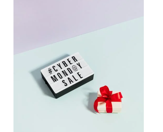 image showcasing Cyber Monday sale in words and a gift box with a red bow on a blue background