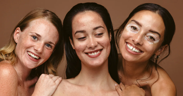 Three beautiful women posing for a photo and smiling