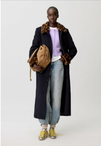 A lady wearing a Claudie Pierlot coat in a casual manner with sneakers from their Designer clothing offers