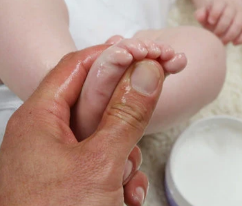 A parent moisturising a baby's feet with Kokoso Baby products