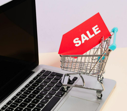 A-Red-Sale-Tag-on-a-Miniature-Shopping-Cart-Placed-on-a-Macbook-Laptop