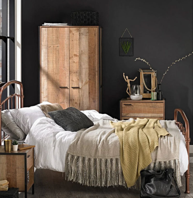 A room with a neatly made wooden frame bed, wardrobe, and bed side tables