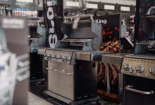 Mehrere Öfen und Grills aus Metall mit einigen Fahnen und Postern