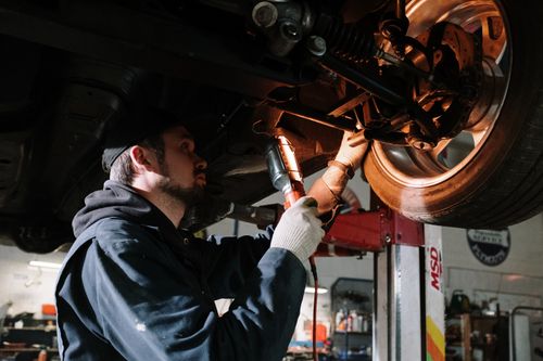 A trained mechanic performing on of the motoring services you can save on with a Halfords discount code