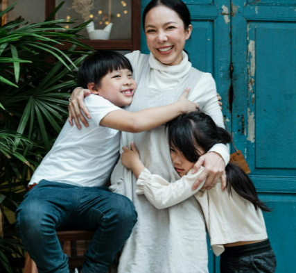 Woman-Hugging-Her-Children-While-Smiling