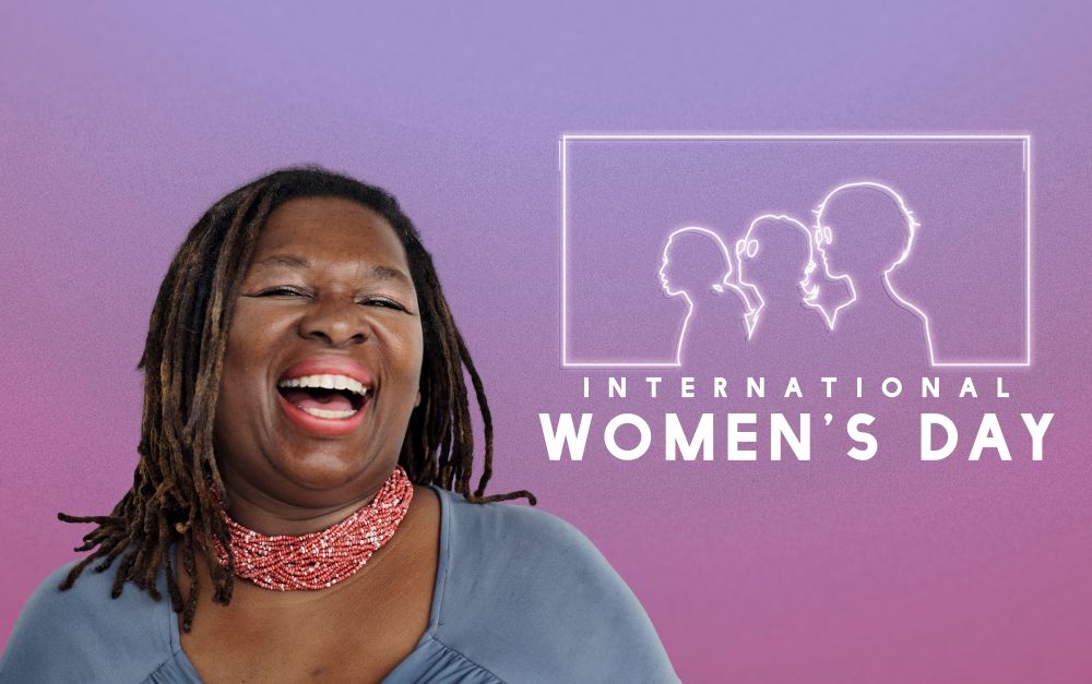an african woman with dreads smiling beside an International Women's Day logo on a purple background