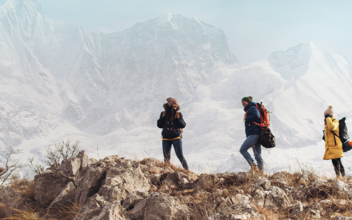 Mehrere Menschen in Winterkleidung auf einem Berggipfel