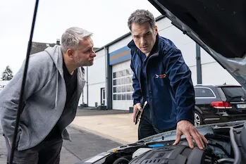 imagen de la web de compramostucoche de dos personas examinando un coche