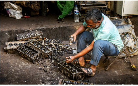 A mechanic fixing a car part
