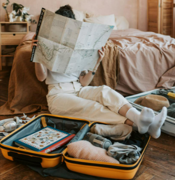 Person in white pants sitting on the floor preparing their trip with ESky