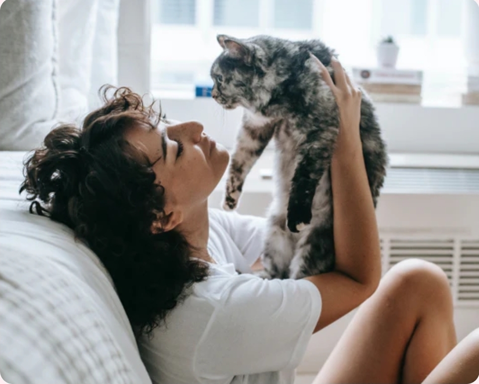 A woman taking care of her cat by giving it attention