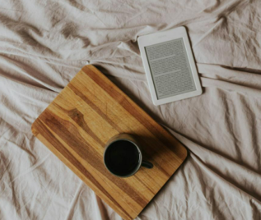 Cozy bedroom scene with an E-Reader and am coffee