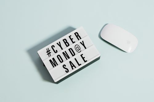 A white sign with the words "Cyber Monday Sale" on it with a computer mouse next to it