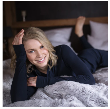 A woman lying on her bed wearing a black sleepwear set bought with a Dagsmejan voucher code