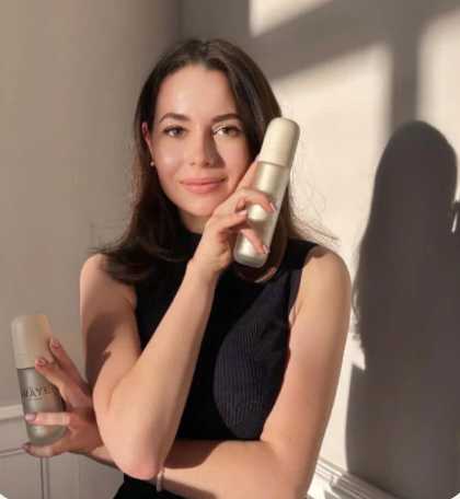 A woman holding IRÄYE serum that she saved on with an IRÄYE voucher code