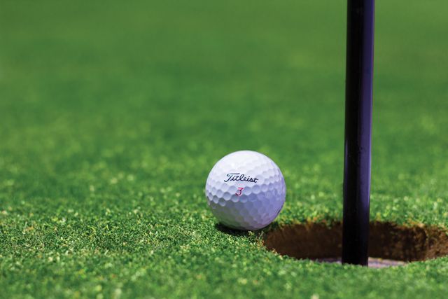 A Titleist ball that someone saved on with a HotGolf voucher code about to to roll into the hole