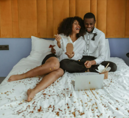 Couple watching a movie on their laptop on a bed