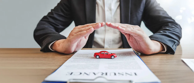 Ein Mann, der mit zwei Hände ein Spielzeugauto umschließt