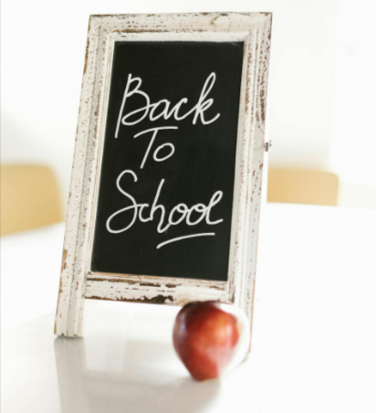 A chalkboard with Back to School text and a red apple.