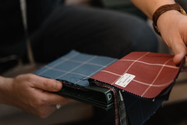 A man looking through a book of different fabric swatches