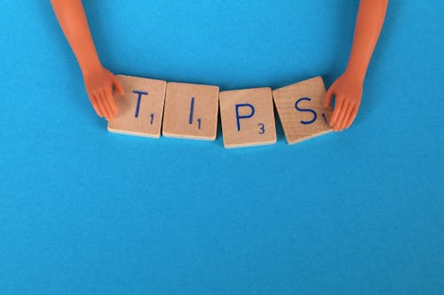 Two plastic hands holding the word "Tips."