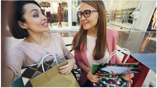 Two female friends taking a picture after a shopping experience at the mall