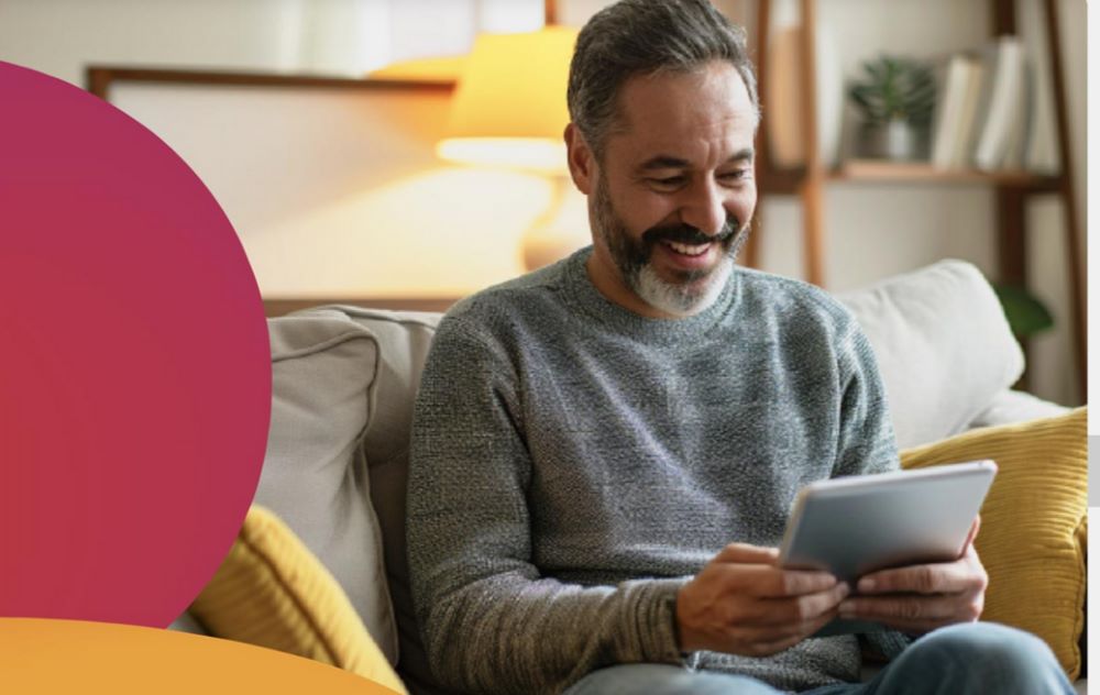 BeFibre-–-Full-Fibre-broadband man looking down smiling at a tablet
