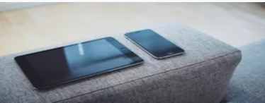 Tablet and phone on a grey sofa