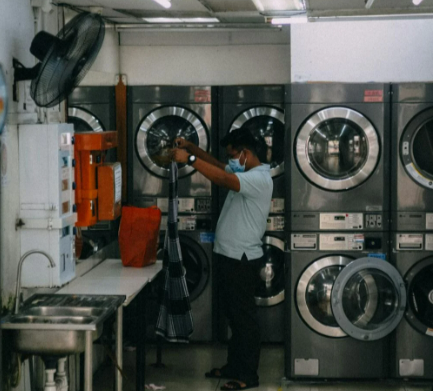 A man in the laundry shop with washing machines supplied by Currys Business