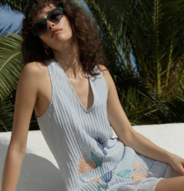 A woman wearing a French Connection Larina Pleated Floral Applique Blue Mini Dress