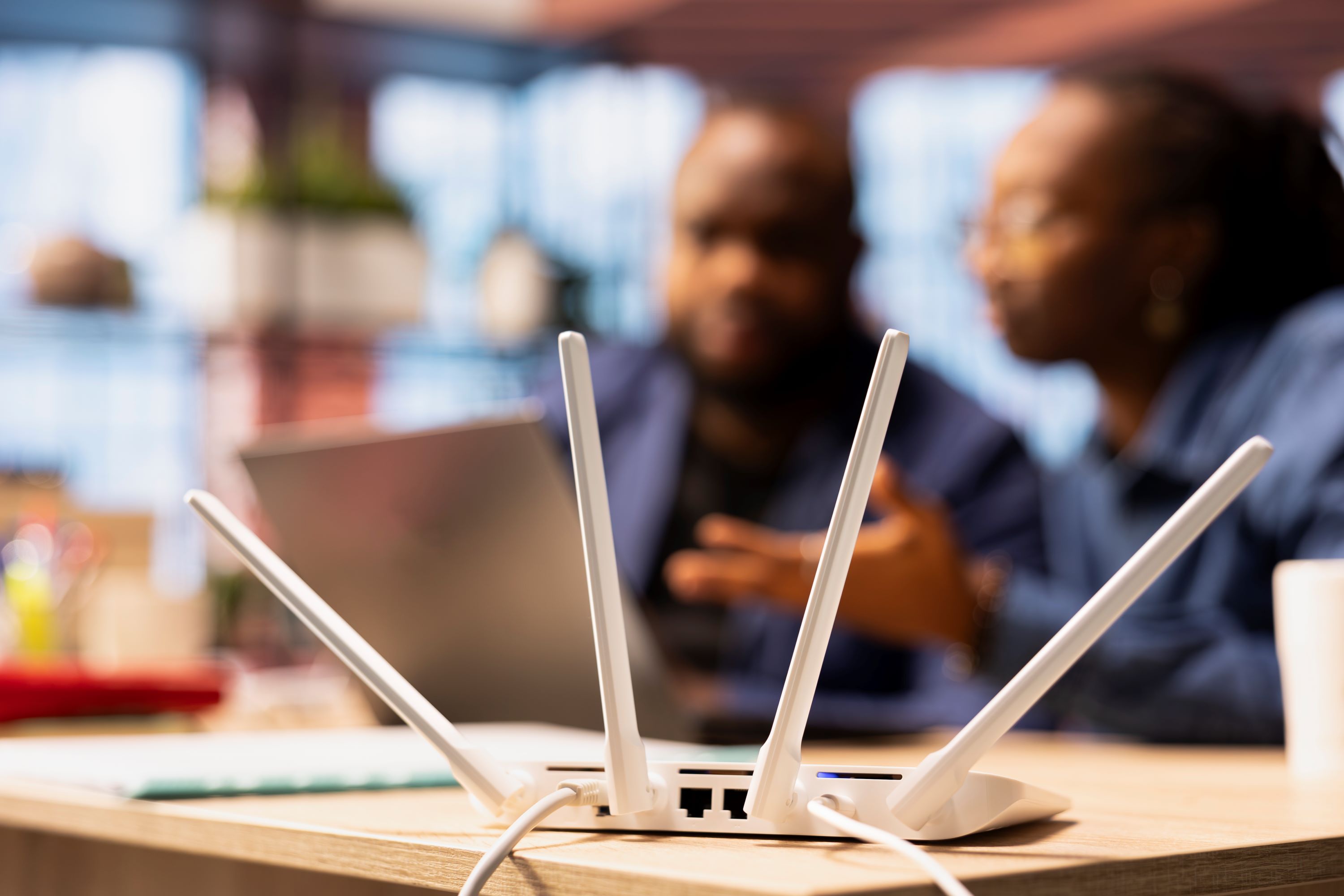 white wifi modem with a blurred couple in the background